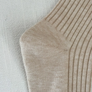 Close-up of beige ribbed knit socks showing high-quality warm fiber texture and stitching