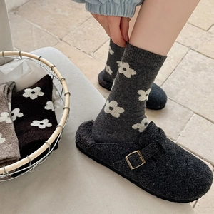 Detail of dark grey wool blend socks with white flower patterns and warm knitted texture