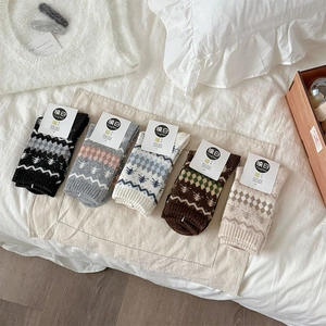 Dettaglio di cinque paia di calze di lana vintage con motivi Fair Isle e confezione