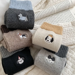 Detailed close-up of colorful cartoon dog embroidery on thick wool crew socks