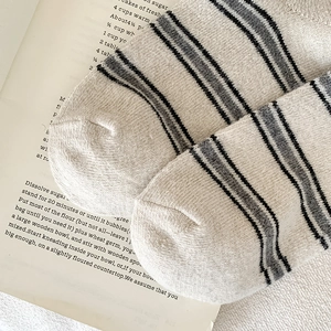 Gros plan de chaussettes en laine à rayures montrant la texture douce et la couture