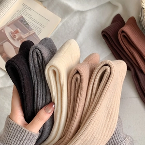 Close-up of thick ribbed knit texture on coffee-toned calf socks in diverse earthy colors
