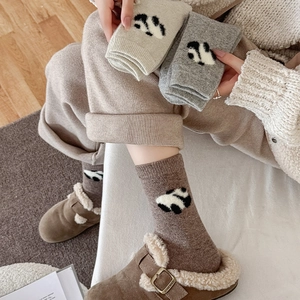 Detail of wool-blend panda crew socks in coffee, beige, and light grey knitted textures
