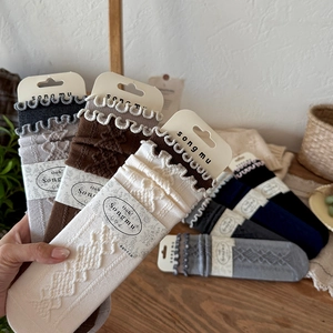 Macro detail of retro diamond knit wool socks with ruffled edges and assorted earthy tones