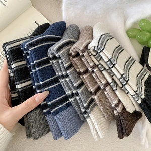 Gros plan de chaussettes en laine rayées épaisses en plusieurs couleurs et texture tricot