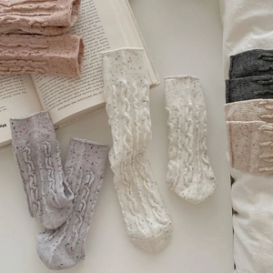 Détails du tricot à torsades sur chaussettes en laine mouchetée rétro sur un livre