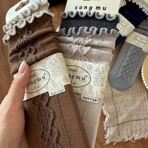 Detailed texture of cable knit wool socks with ruffled cuffs in vintage colors