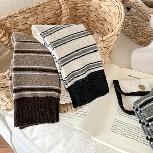 Gros plan de chaussettes en laine rayées sur un livre créant un style douillet