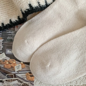 Detail of plush off-white knitted socks with warm fuzzy texture and rib knit pattern