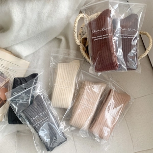 Close-up of assorted ribbed knit mid-calf socks neatly packed in individual zipper bags
