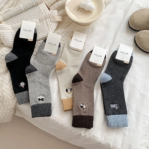 Detailed view of thick knit wool socks set with cute animal embroidery and ribbed cuffs