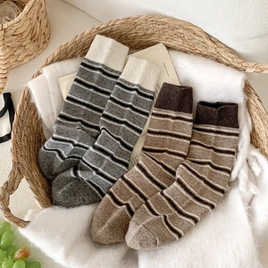 Détail de chaussettes en laine à rayures chaudes avec revers sur fond blanc
