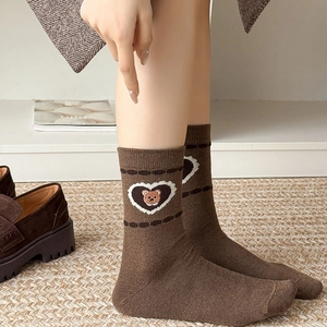 Vintage brown wool socks with cute bear embroidery and heart border in lifestyle setting