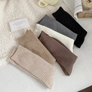 Detail of ribbed knit winter socks in coffee and khaki tones on cozy white fleece
