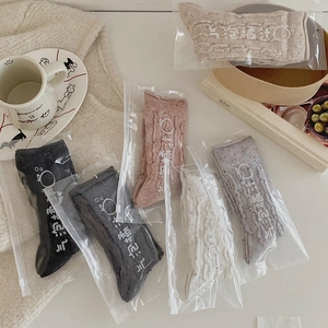 Détail de chaussettes en laine à torsades multicolores avec emballage zippé de marque