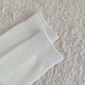 Detailed macro view of white ribbed knit cuff texture on cozy wool calf socks