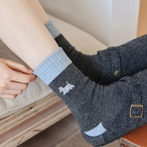Detail of wool socks showing dog embroidery and light blue color block heel
