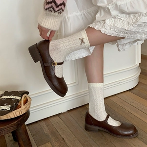 Brown Mary Jane shoes paired with white lace calf socks featuring 3D bow accents