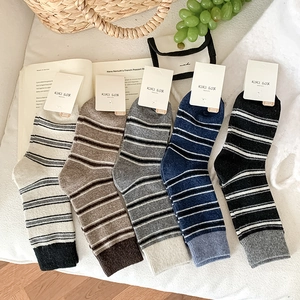 Gros plan détaillé de cinq paires de chaussettes en laine rayées aux tons automnaux