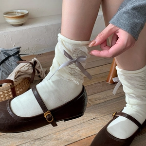 Cream mesh crew socks with satin bow accents paired with vintage Mary Jane shoes