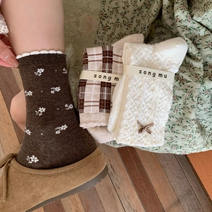 Close-up of floral knit socks and lace ribbon bow detail in a vintage forest style