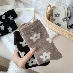 Detailed knit texture of wool socks featuring floral patterns in four neutral colors