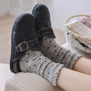 Close-up of warm wool polka dot crew socks with vintage metal buckle felt clogs