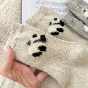 Detail of wool socks featuring 3D plush panda motifs and premium knit texture