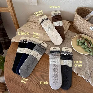 Detail of wool blend socks featuring diamond knit patterns and elegant wavy lace cuffs
