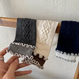 Detail of argyle knit wool socks featuring retro double ruffle trim and textured cuffs