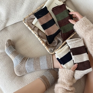 Détail de chaussettes épaisses en laine à rayures avec bords-côtes en plusieurs couleurs
