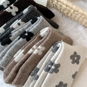 Close-up of thick floral wool socks with knitted patterns in a rustic basket