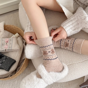 Detailed close-up of cute cartoon bear embroidery on thick oatmeal winter knit socks