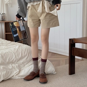 Close-up of retro striped crew socks paired with brown loafers and khaki shorts for fall