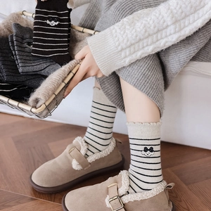 Gros plan de chaussettes rayées en laine avec broderie chien mignon et bordure ondulée