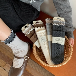 Detail of vintage cable knit wool socks featuring decorative frilly lettuce edge cuffs