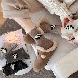 Detail of thick wool socks with cute panda patterns in warm grey and brown tones