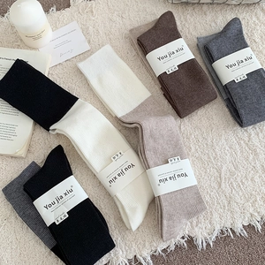 Detail showing wool knit socks in multiple colors with branded paper band packaging