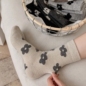 Detail view of floral wool blend socks in beige with ribbed cuffs and vintage patterns