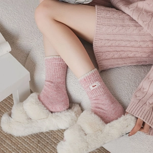 Détail de chaussettes en tricot rose avec étiquette brodée Nice et texture laine