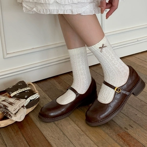 Brown Mary Jane shoes paired with white lace calf socks and floral relief accents