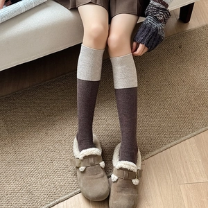 Detail of wool knit socks showing bicolor beige and brown texture with cozy styling
