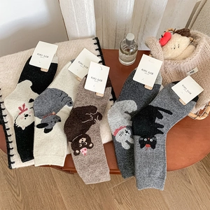 Detail of five pairs of warm cartoon animal socks in neutral colors with Kiki Sox tags