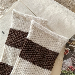 Gros plan de chaussettes en laine à rayures marron et beige avec texture côtelée