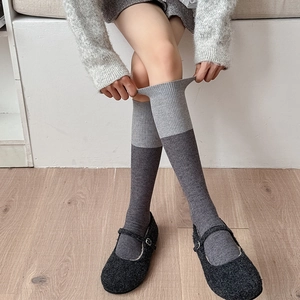 Close-up of color-block ribbed wool stockings showing detailed knit texture and elasticity