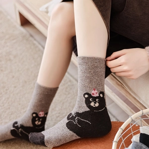 Detail of warm grey mid-calf socks with cute cartoon bear pattern and reinforced heels