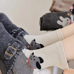 Close-up of thick wool socks with cute cartoon dog pattern and ribbed knit cuffs