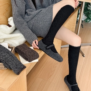 Detail of warm black cable knit over-the-knee socks with wool felt Mary Jane home shoes