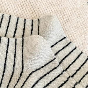 Gros plan de chaussettes à rayures crème montrant la texture en maille douce et les coutures