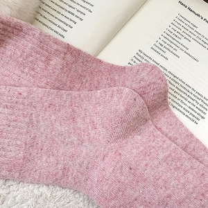 Gros plan de chaussettes épaisses en laine rose tricotée sur fond de fausse fourrure
